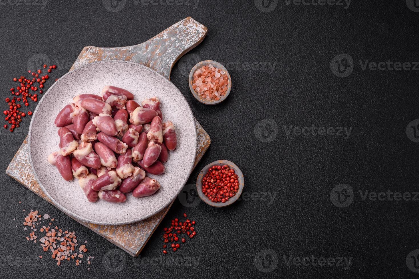 Raw chicken hearts with salt, spices and herbs photo