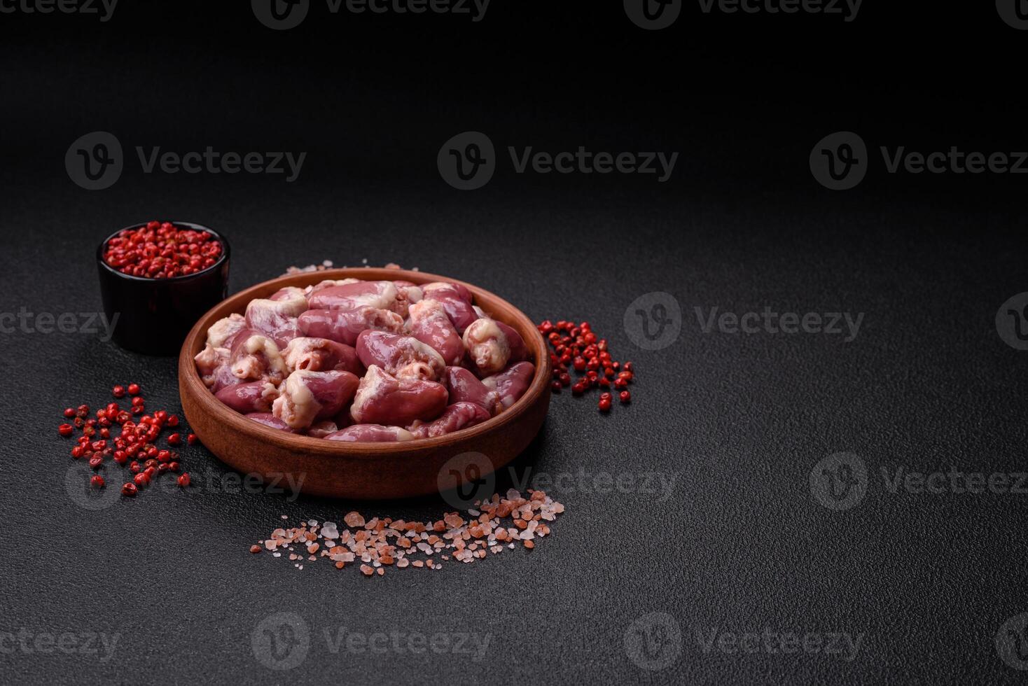 Raw chicken hearts with salt, spices and herbs photo
