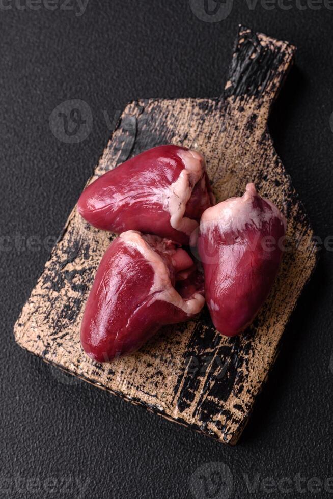 Raw turkey or chicken hearts with salt and spices photo