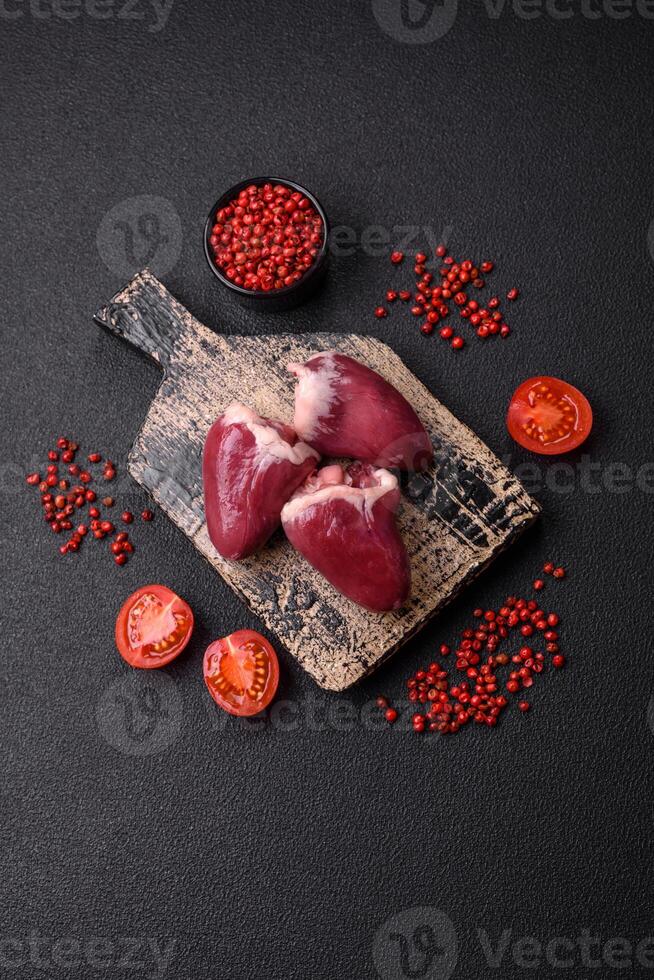 Raw turkey or chicken hearts with salt and spices photo