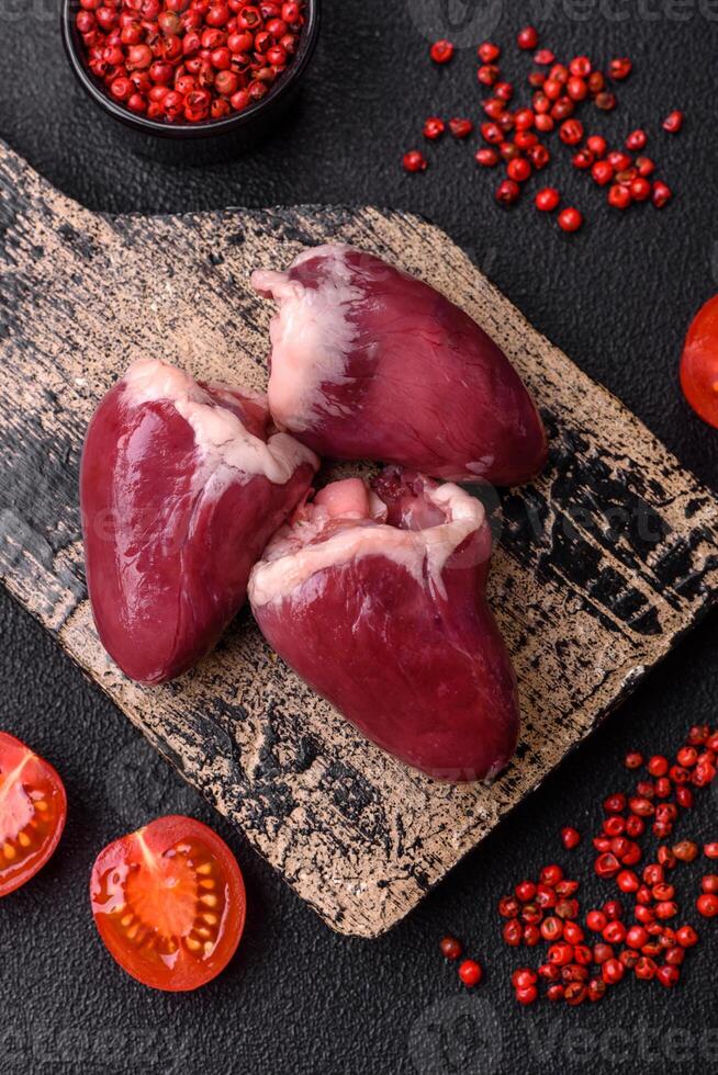 Raw turkey or chicken hearts with salt and spices photo