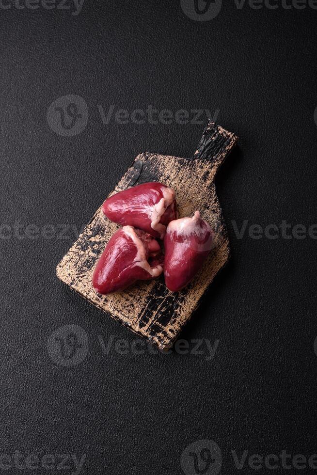 Raw turkey or chicken hearts with salt and spices photo