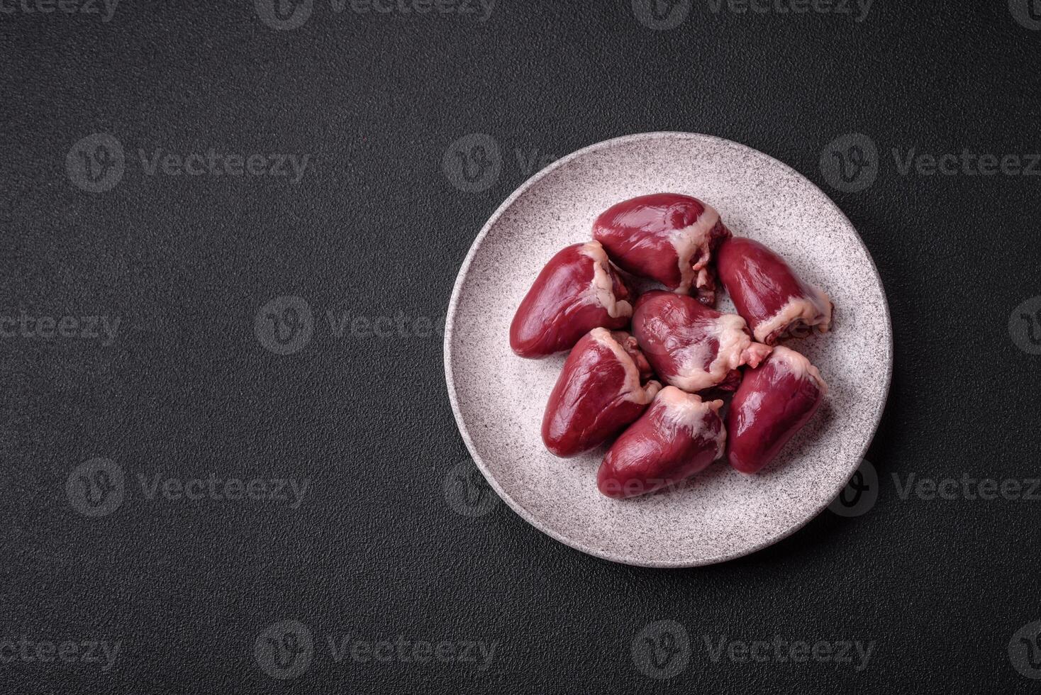 Raw turkey or chicken hearts with salt and spices photo