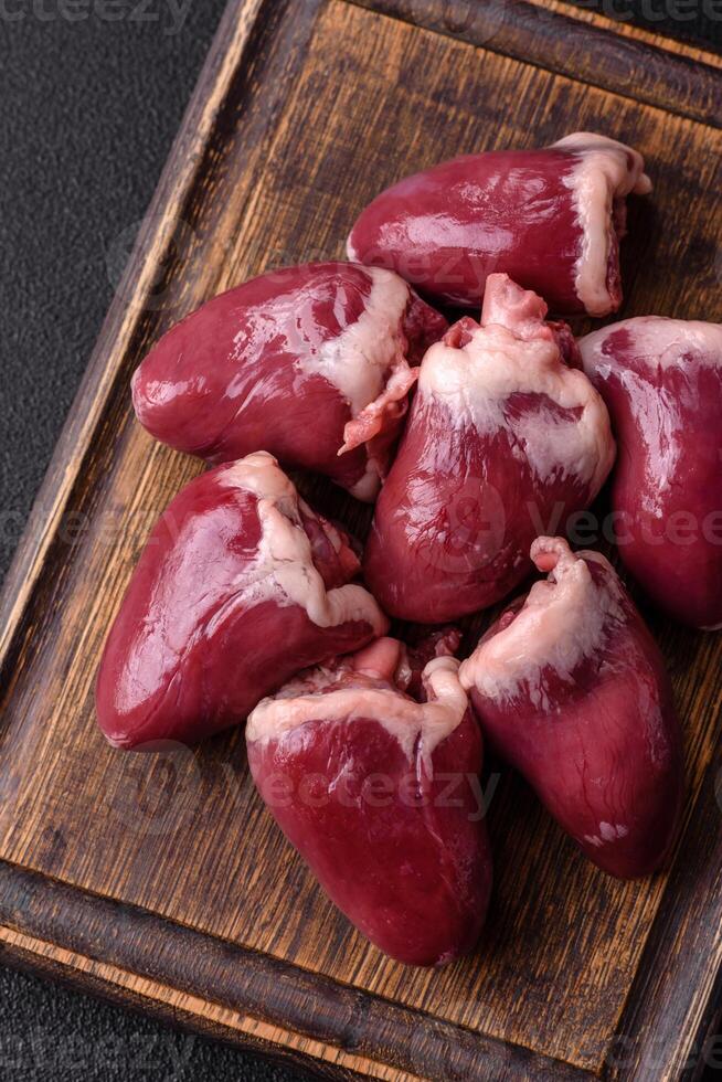 Raw turkey or chicken hearts with salt and spices photo