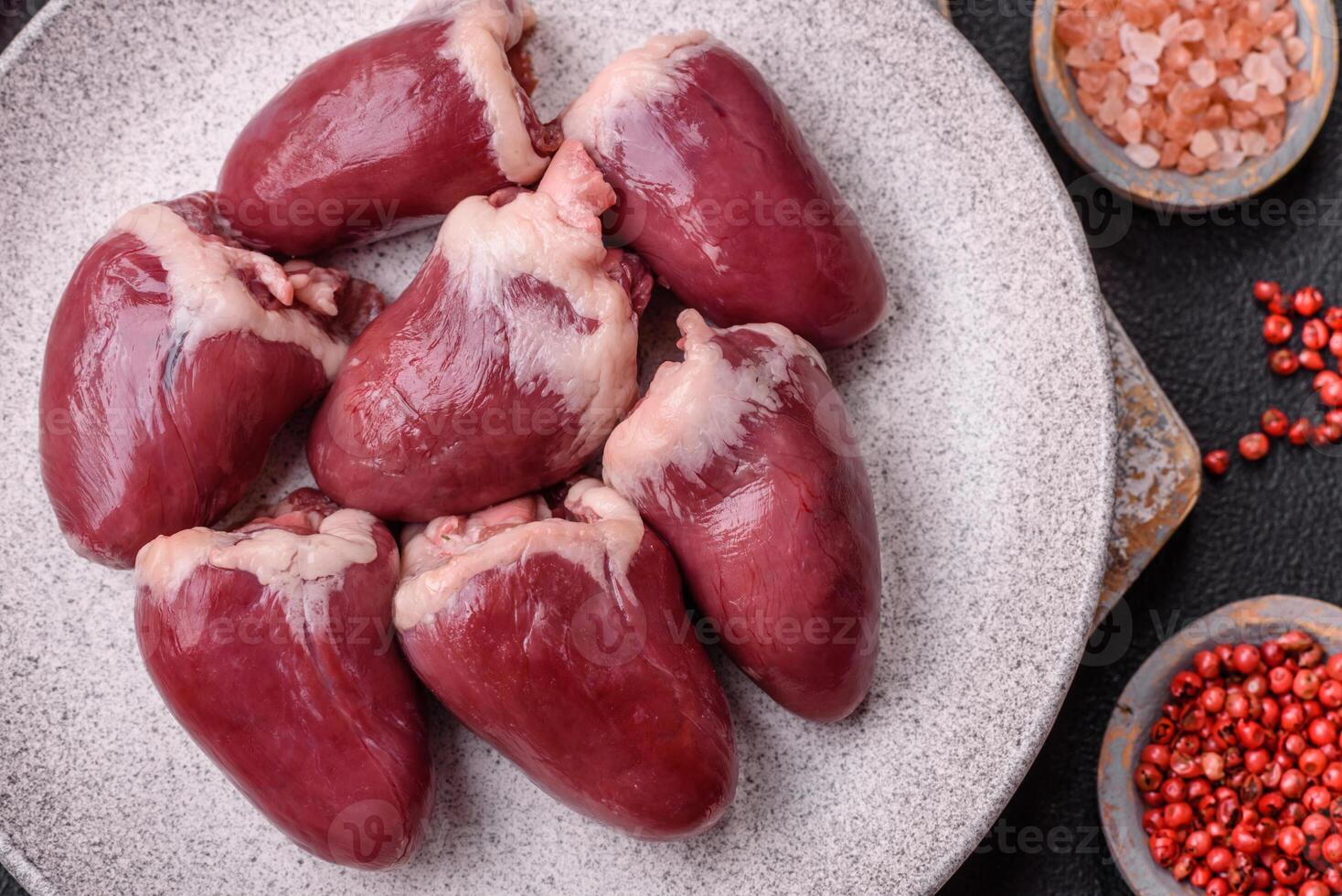 Raw turkey or chicken hearts with salt and spices photo