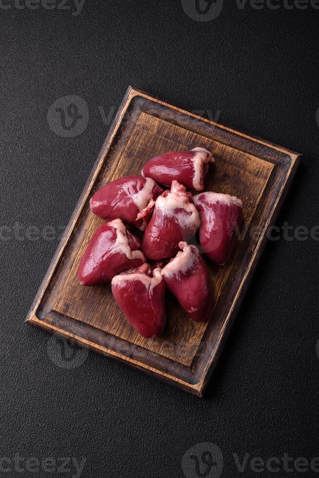 Raw turkey or chicken hearts with salt and spices photo