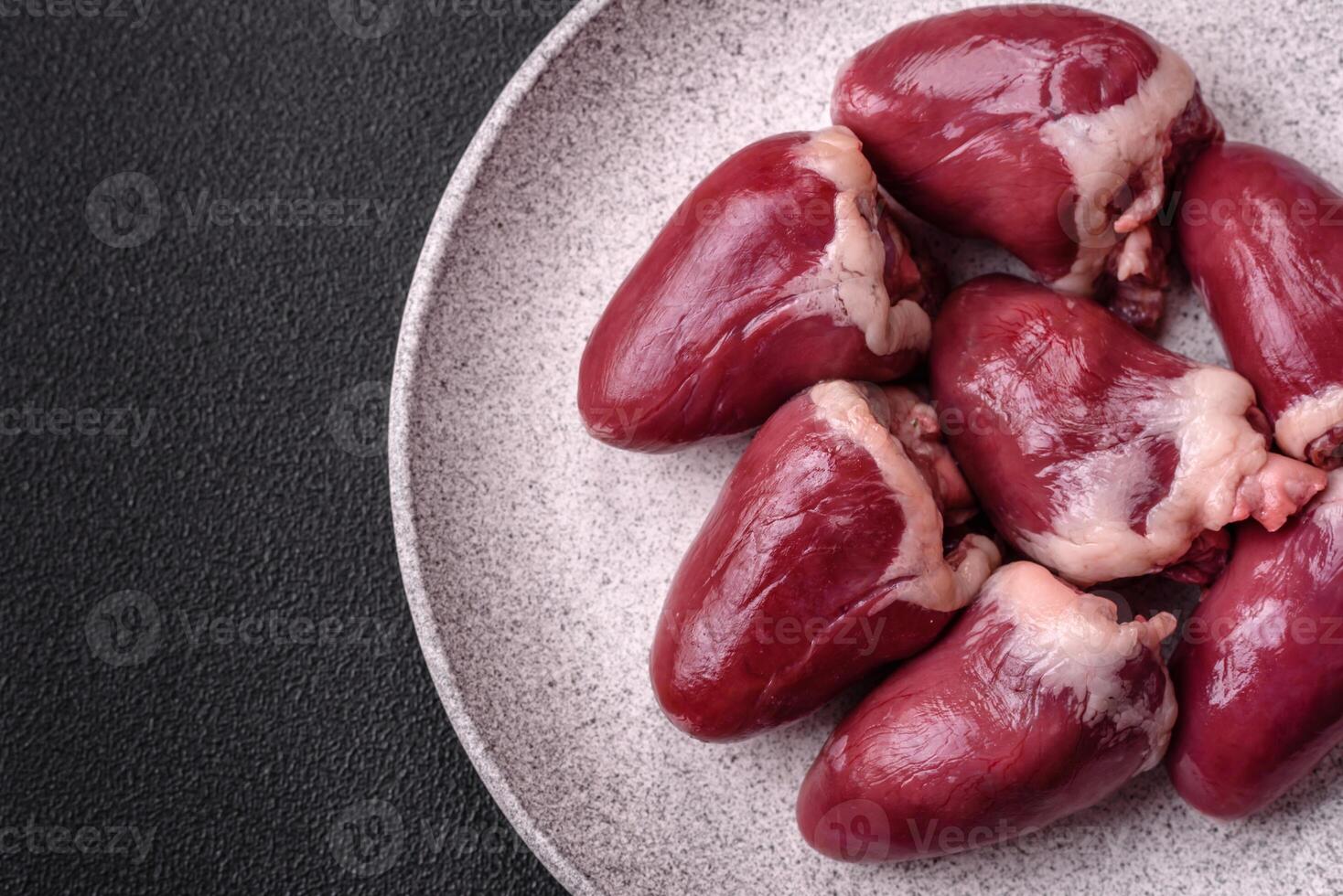 Raw turkey or chicken hearts with salt and spices photo