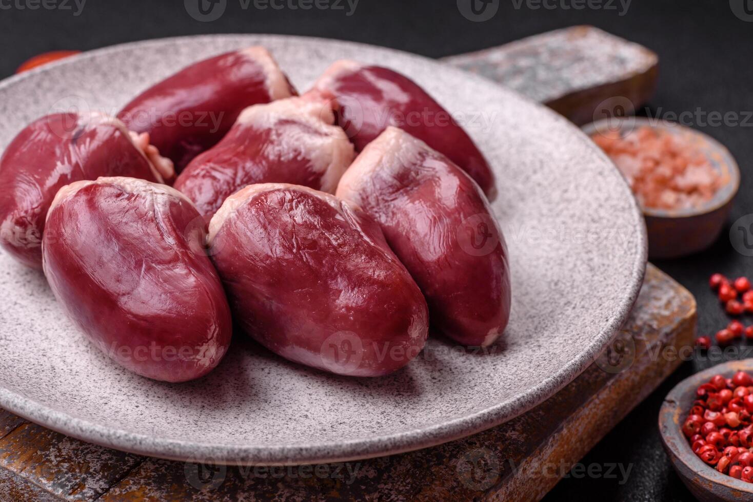 Raw turkey or chicken hearts with salt and spices photo