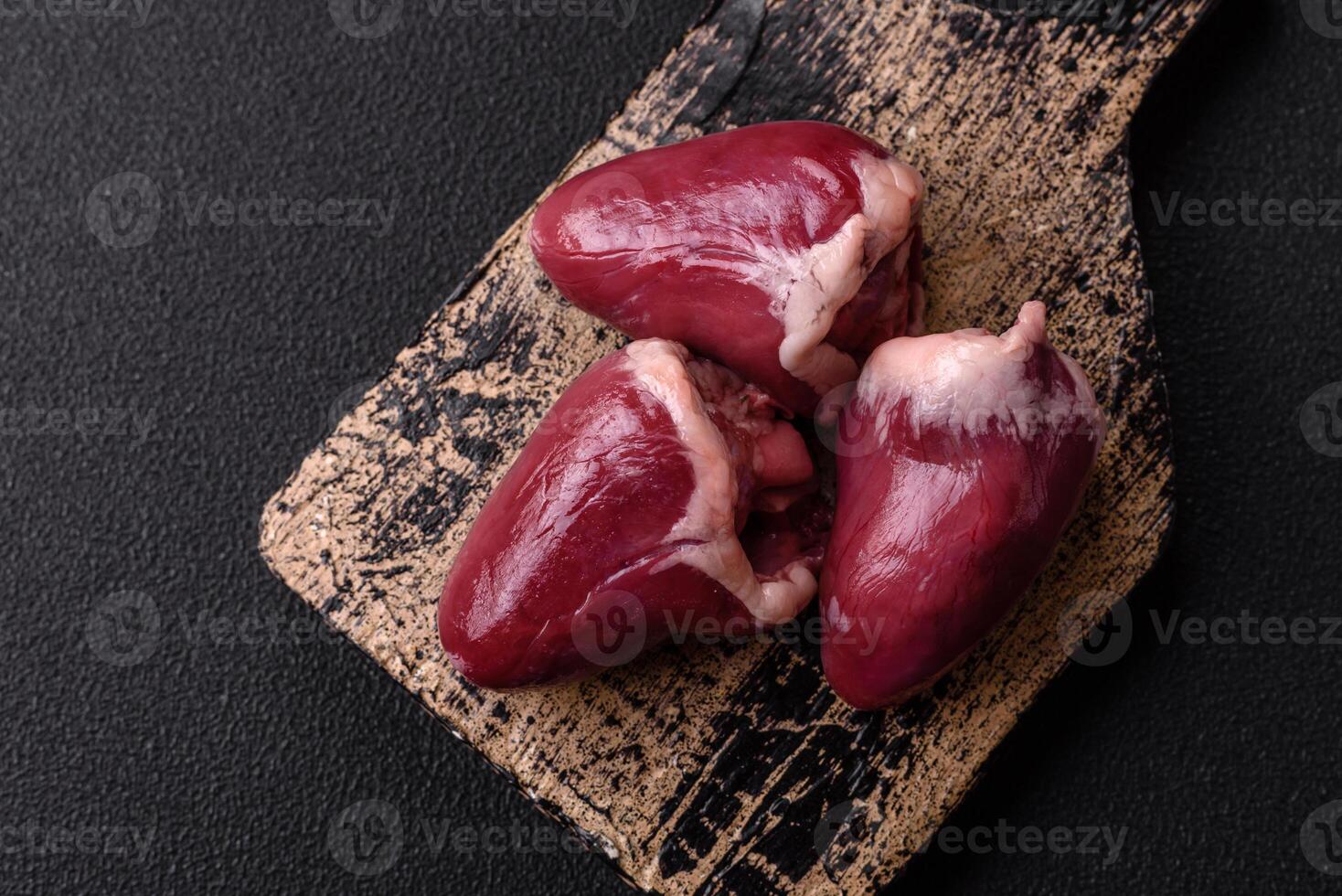 Raw turkey or chicken hearts with salt and spices photo