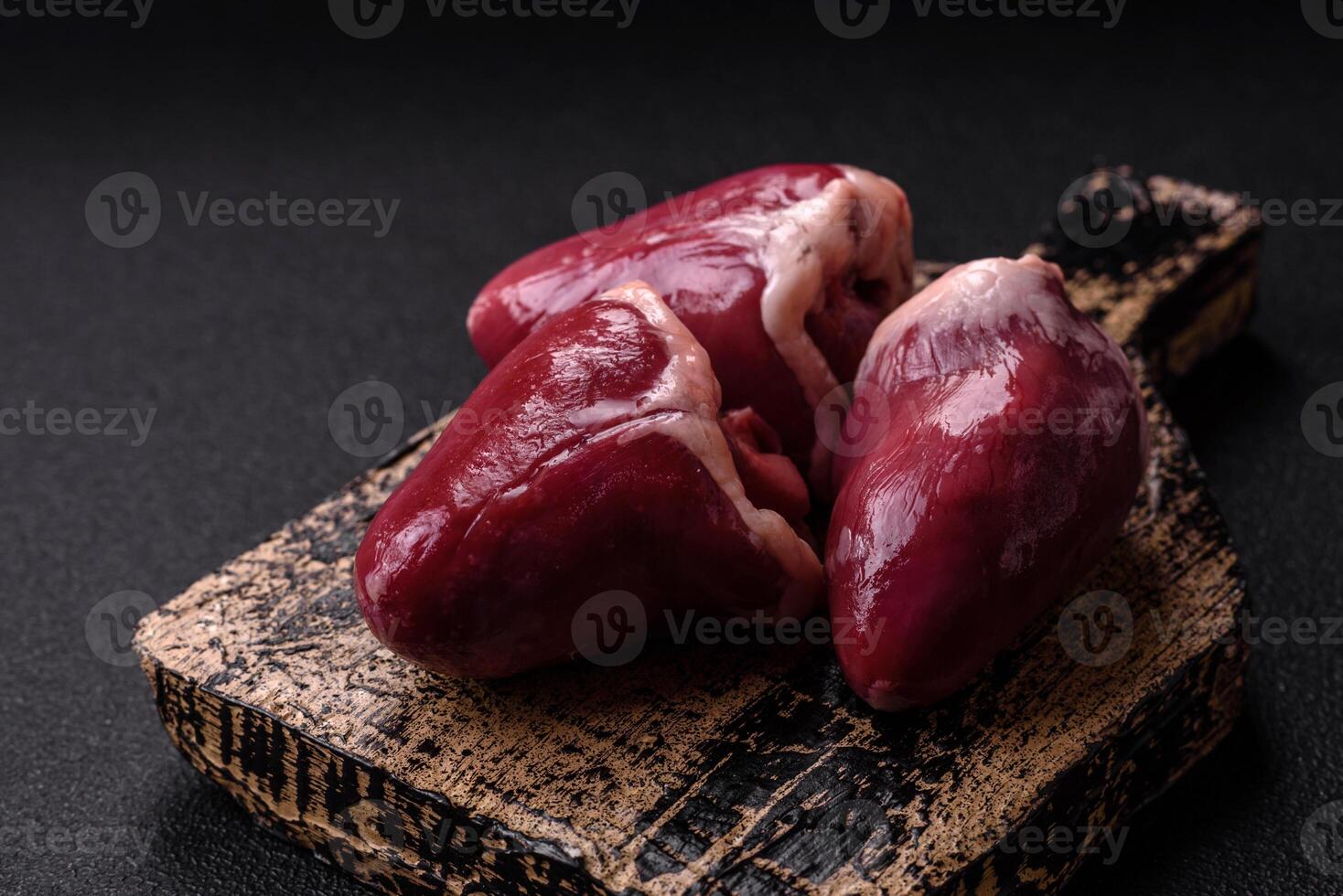 Raw turkey or chicken hearts with salt and spices photo