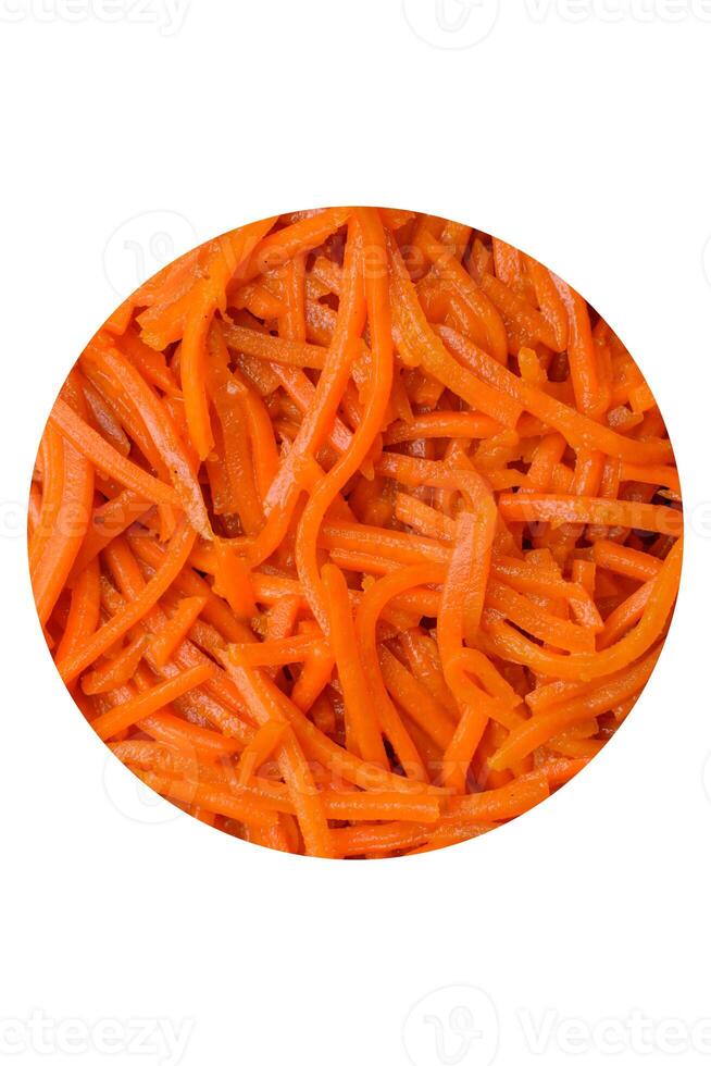 Tasty spicy Korean carrot with spices and herbs on a dark concrete background photo