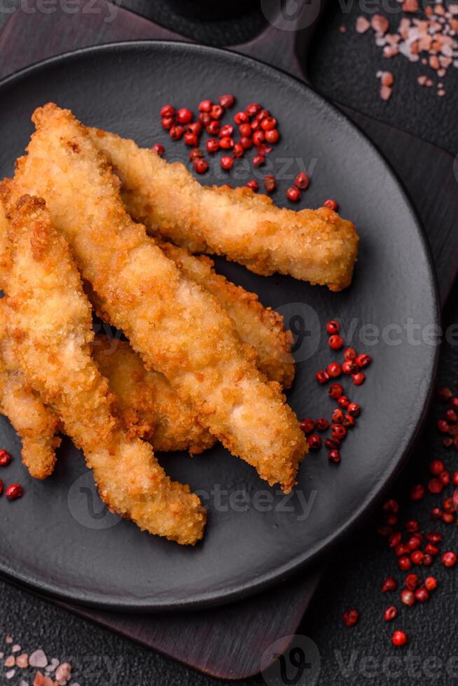 Delicious fresh chicken or turkey strips or nuggets breaded with salt and spices photo