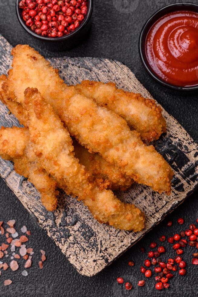 Delicious fresh chicken or turkey strips or nuggets breaded with salt and spices photo