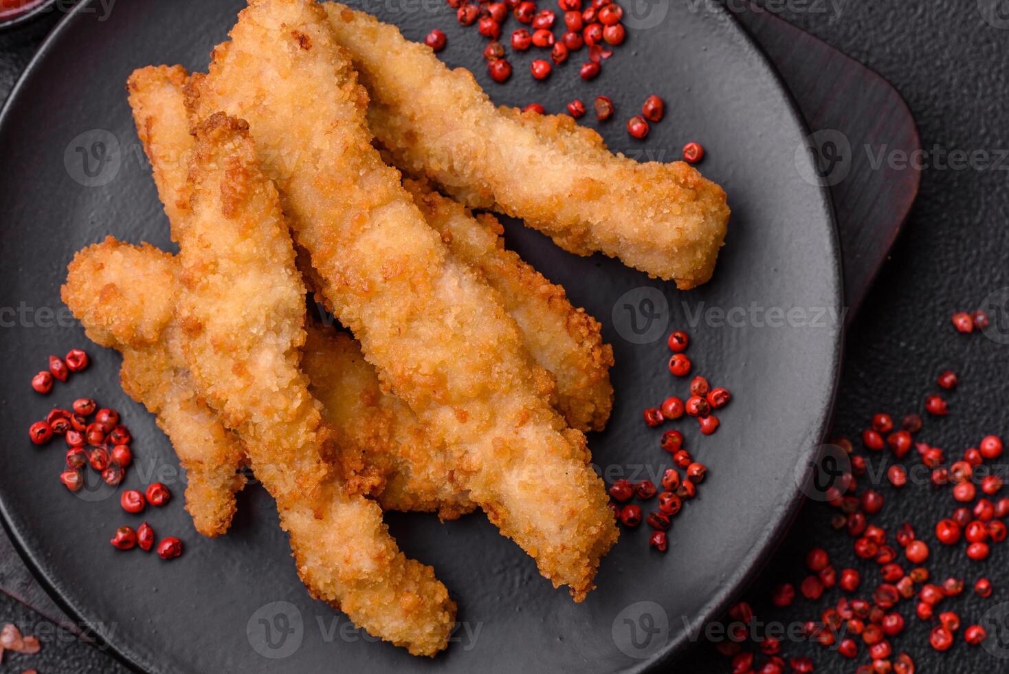 Delicious fresh chicken or turkey strips or nuggets breaded with salt and spices photo