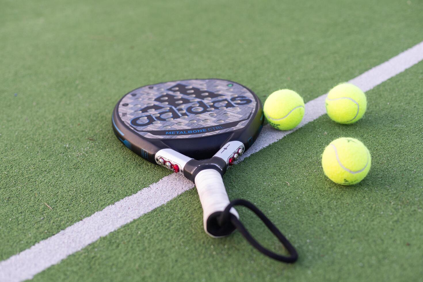 Ukraine Kyiv, 30.03.2024. Padel racket adidas and padel ball on a green court photo