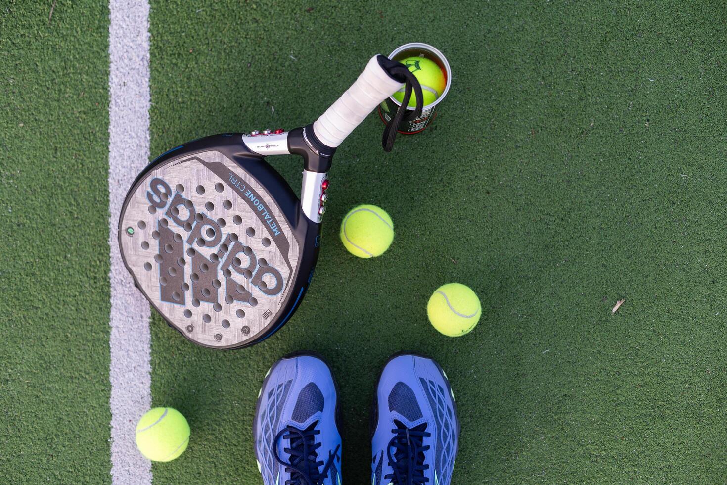 Ukraine Kyiv, 30.03.2024. Padel racket adidas and padel ball on a green court photo