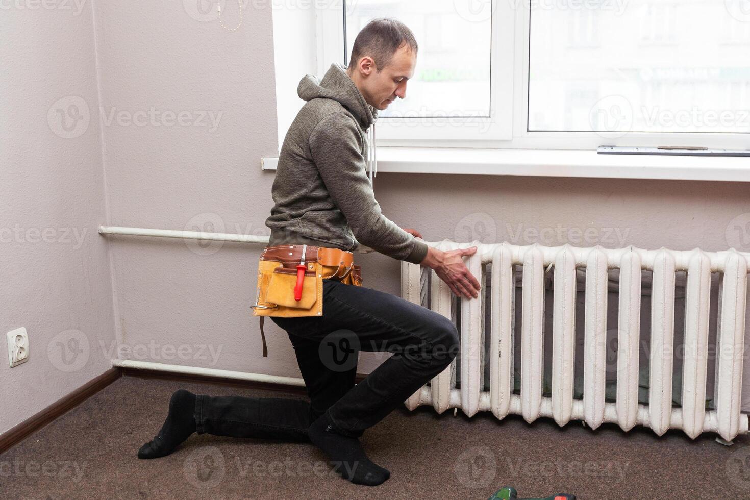 Central heating mechanic and handyman fixing home radiator, gas crisis and seasonal issues. photo