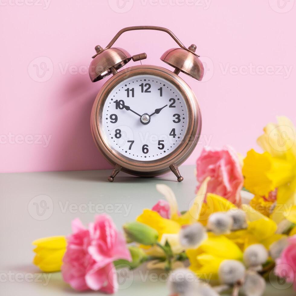 Alarm clock with spring flowers. Spring time, daylight savings concept, spring forward photo