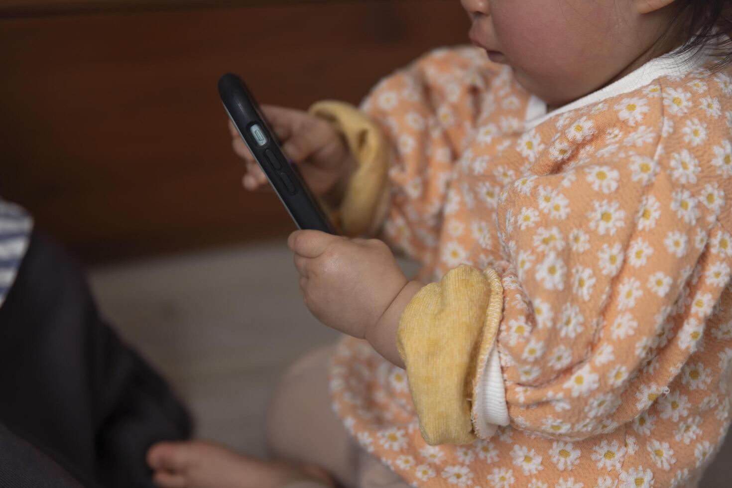 Child's hands with smartphone in the living room closeup photo