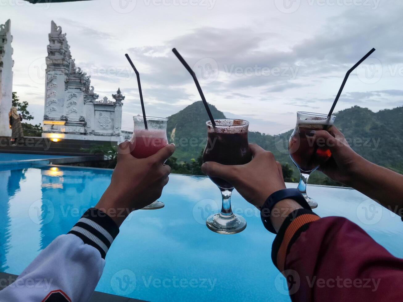 three glasses toasting each other behind the beautiful mountain views photo