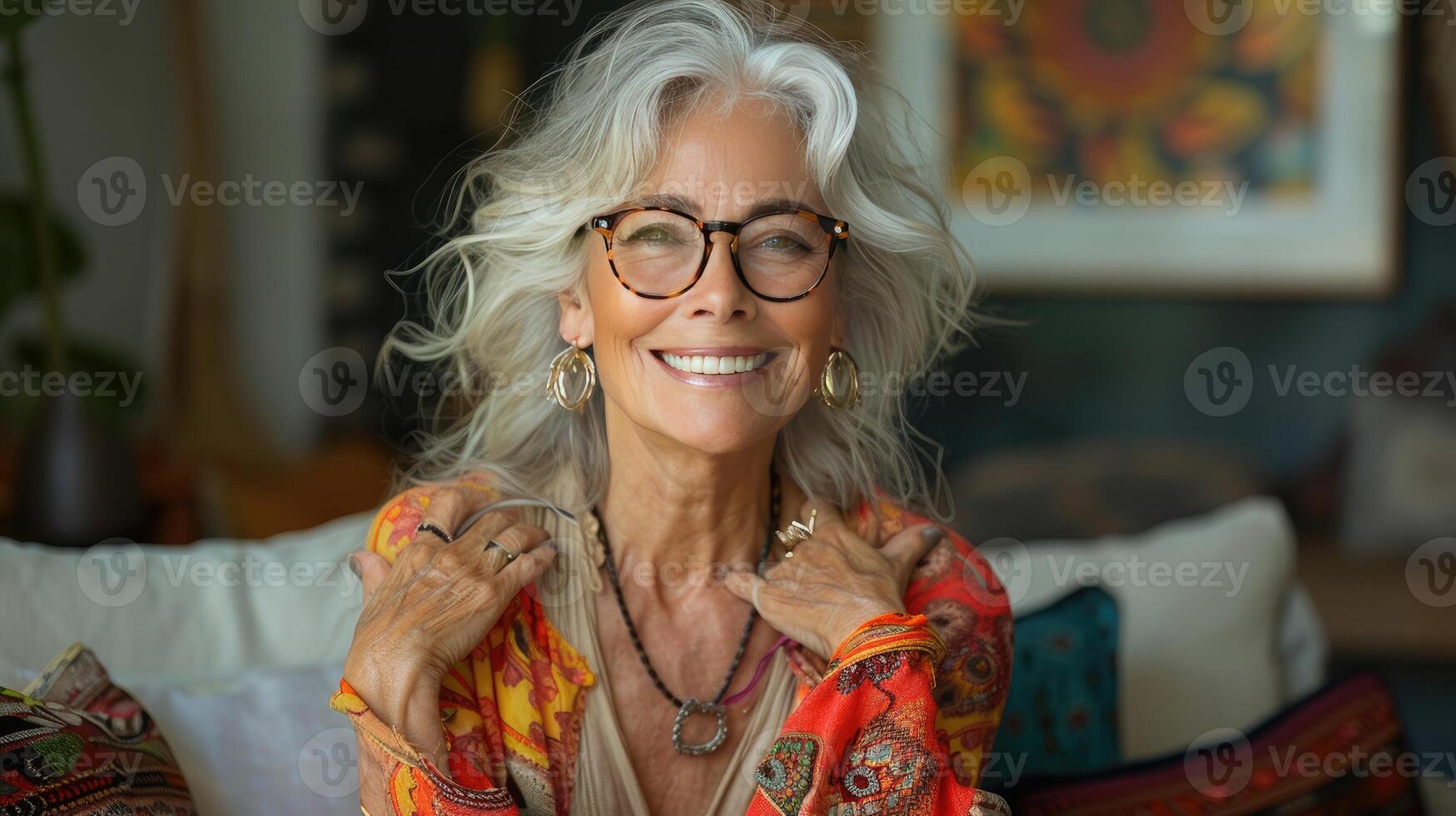 Cheerful pretty older woman in elegant glasses sitting on cozy home photo