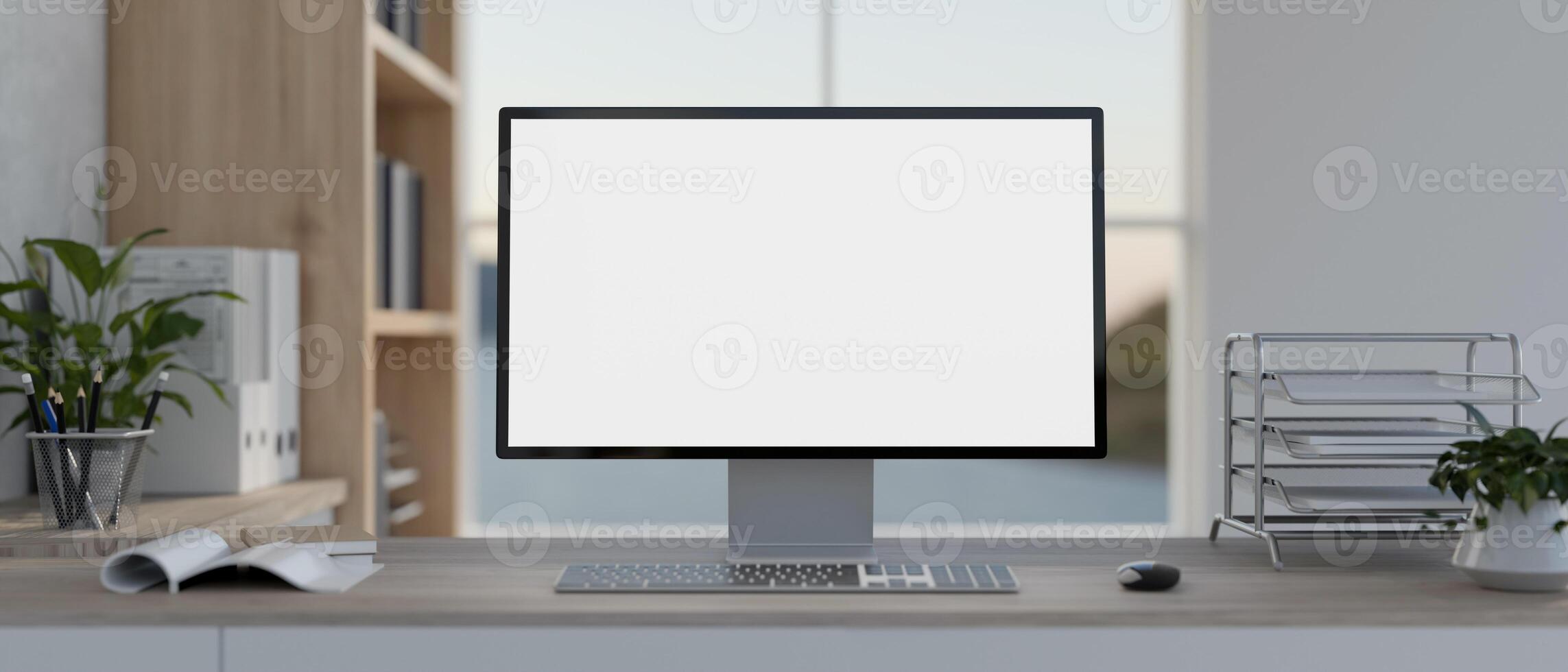 A front view of a PC computer mockup and office supplies on a table in a modern white office. photo