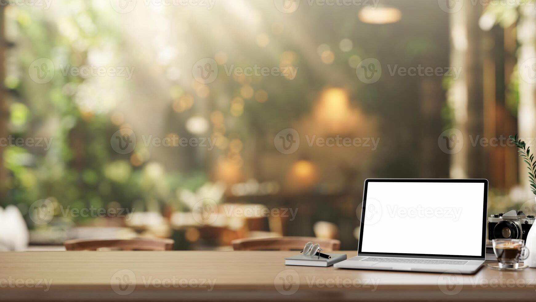 A laptop computer with a white screen mockup on a rustic wooden table in a beautiful cafe garden. photo
