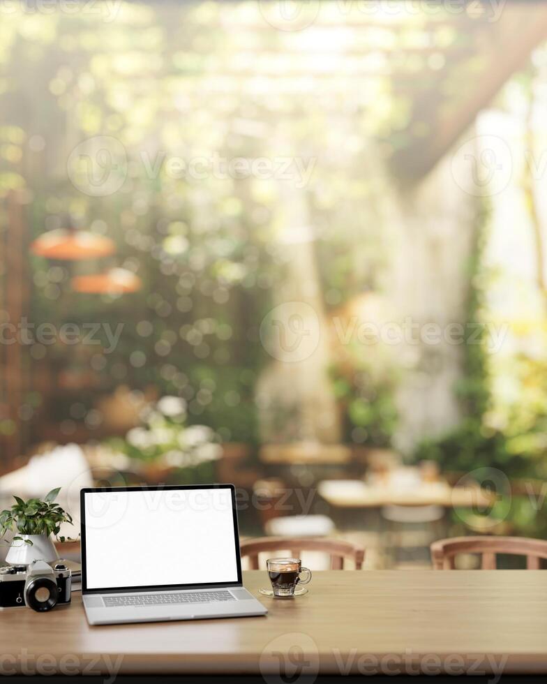 A laptop computer mockup adorn a wooden table in a beautiful green restaurant or cafe garden. photo