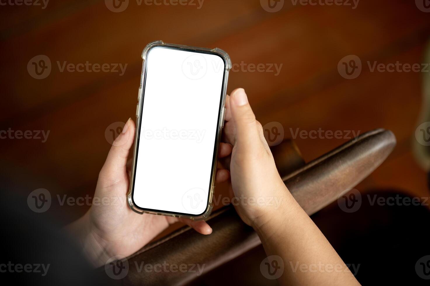 A close-up image of a woman using her smartphone indoors. A white-screen smartphone mockup photo