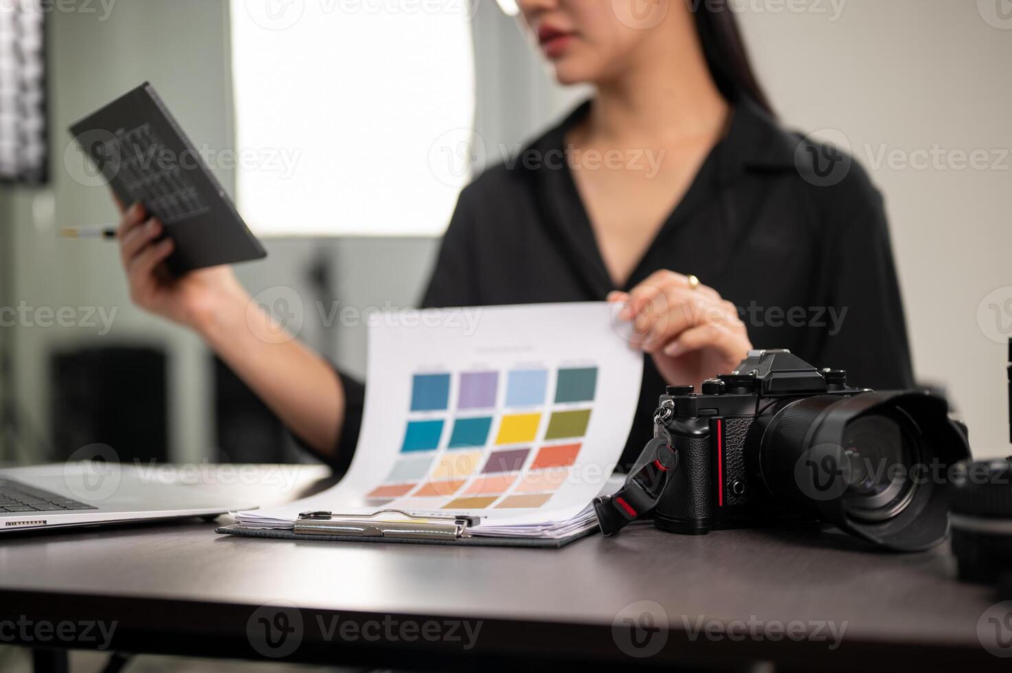 A close-up image of a professional DSLR camera on a desk in a studio. photo