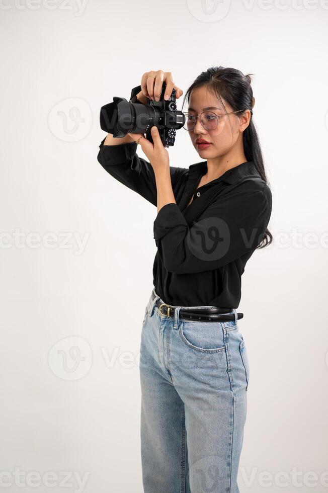 un profesional, confidente asiático hembra fotógrafo es tomando imágenes en un Sesión de fotos estudio.