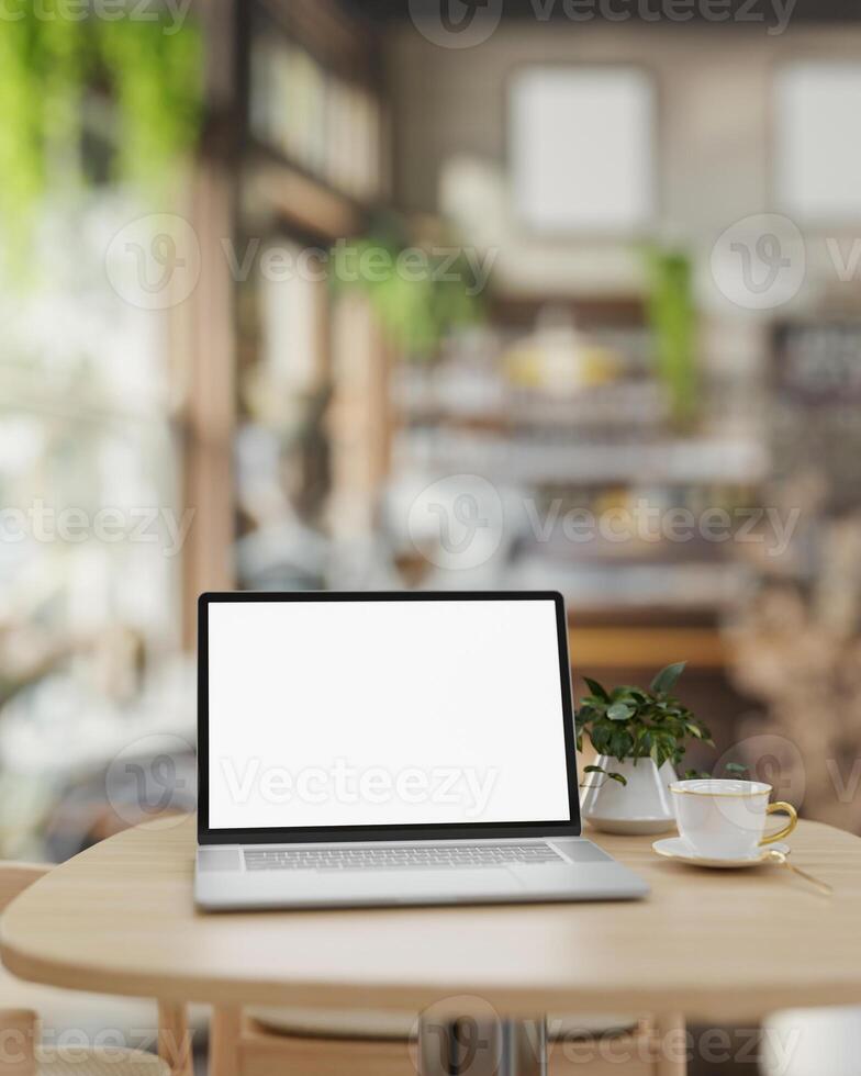 A white-screen laptop computer mockup on a wooden table in a contemporary cosy coffee shop. photo