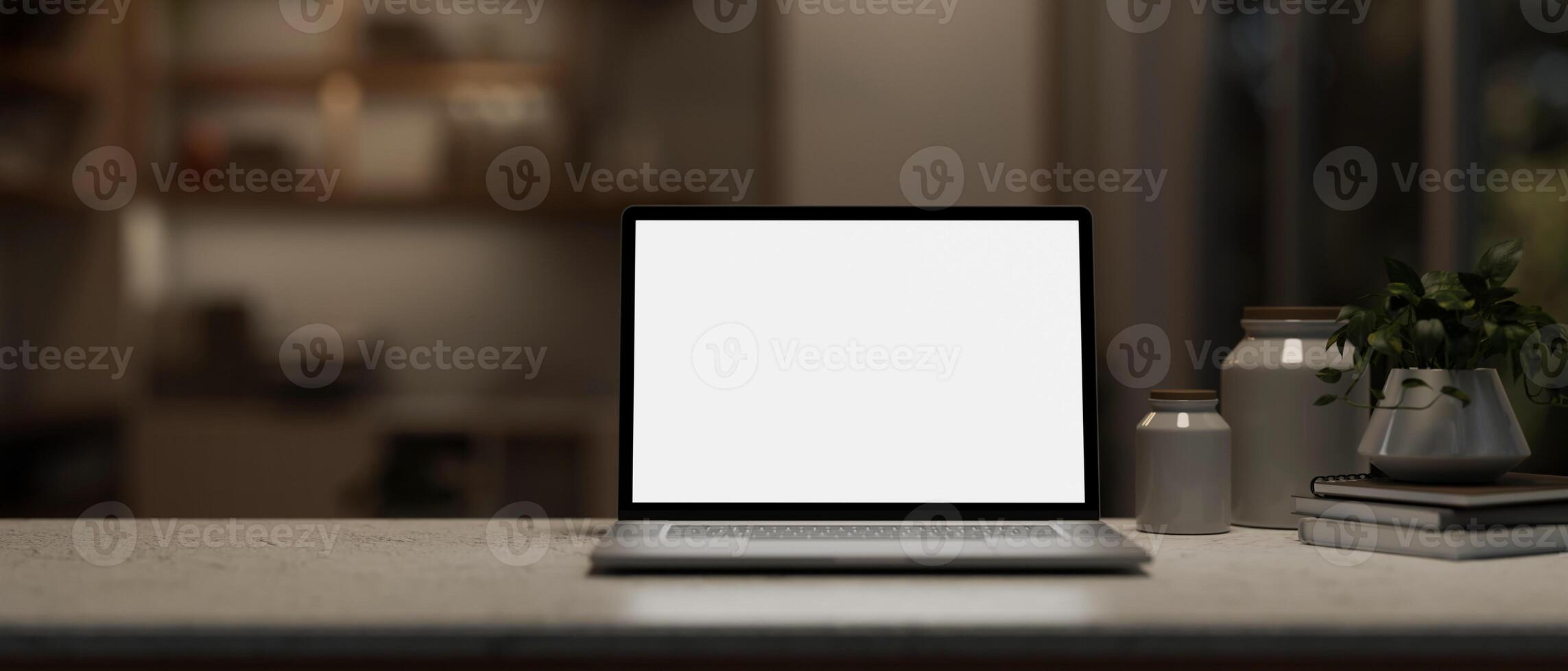 A close-up image of a white-screen laptop computer mockup on a desk in a modern dark room at night. photo