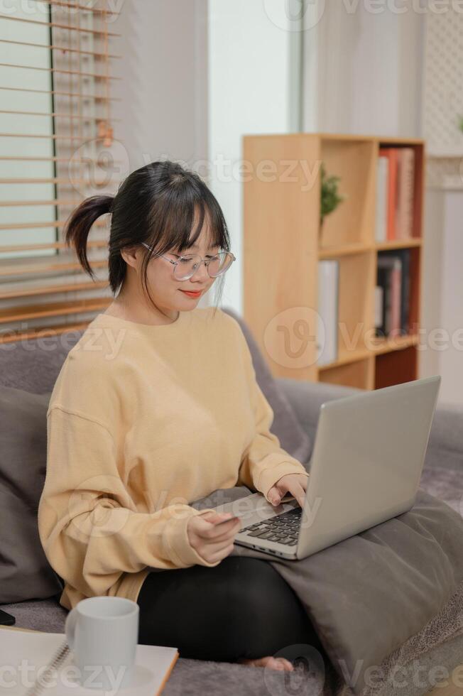 A woman is registering her credit card on a shopping website, enjoying shopping online at home. photo