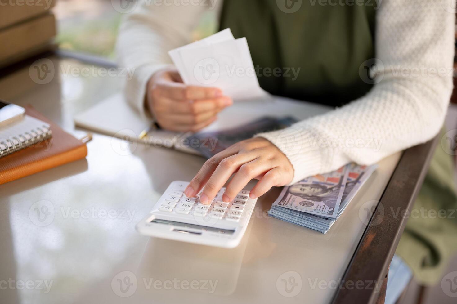 A female small business owner using a calculator, calculating bills, planning her shop expenses. photo