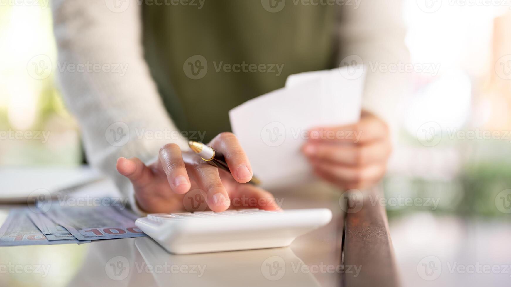 A female business owner using a calculator, reviewing receipts, and managing her shop's finances. photo