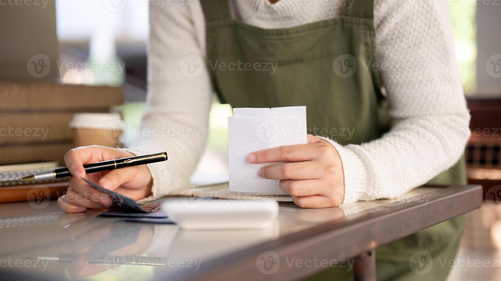 un hembra pequeño negocio propietario calculador su mensual gastos, comprobación cuentas ingresos. foto