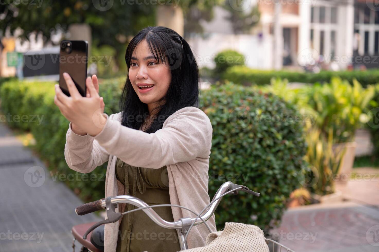 un mujer es tomando un imagen de el ciudad con su teléfono inteligente mientras explorador eso con su bicicleta. foto