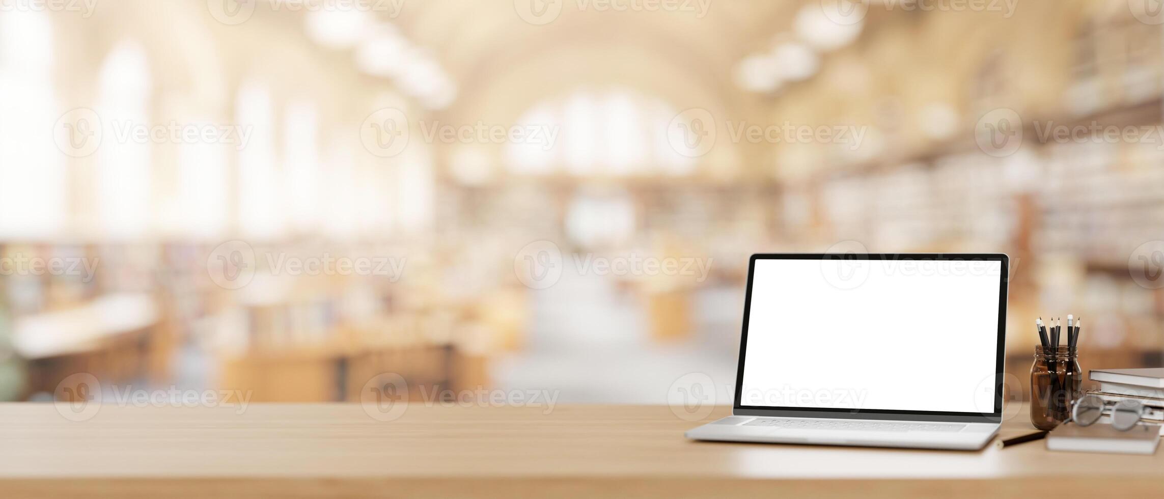 A laptop computer mockup on a wooden desk with a blurred background of a beautiful spacious library. photo