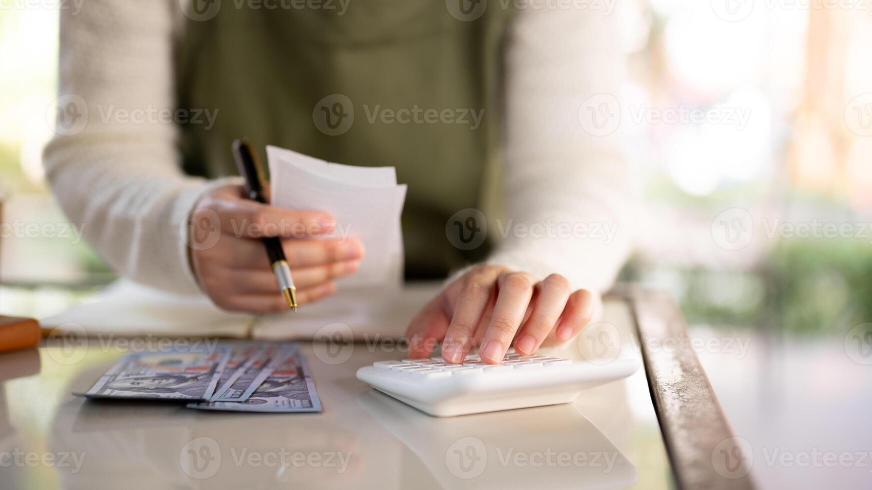 A female business owner using a calculator, reviewing receipts, and managing her shop's finances. photo
