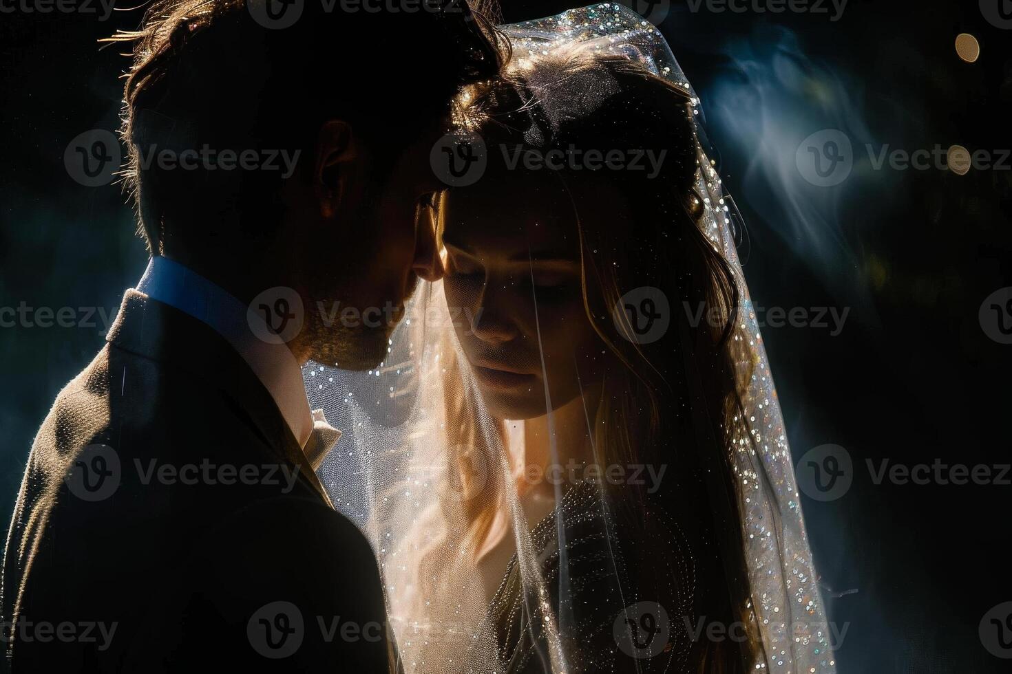 Wedding of a man and a woman. They hug and pose for a photo. Warm colors, dark background. Mysterious atmosphere photo