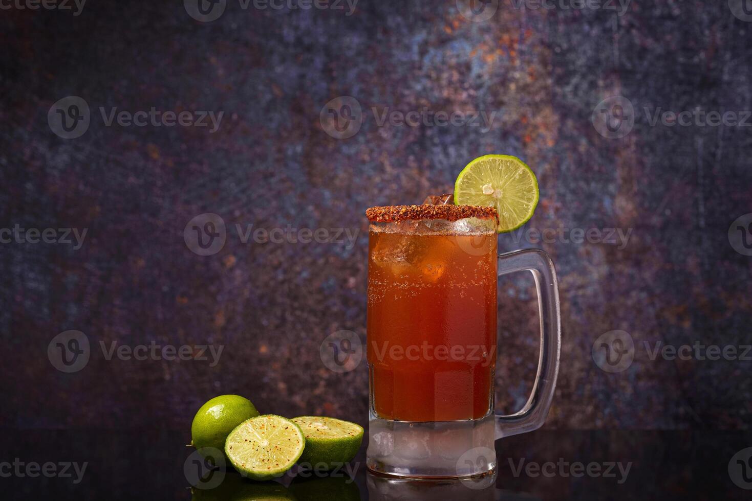 Michelada, typical mexican cocktail on a wooden table. Cocktail based on beer. photo