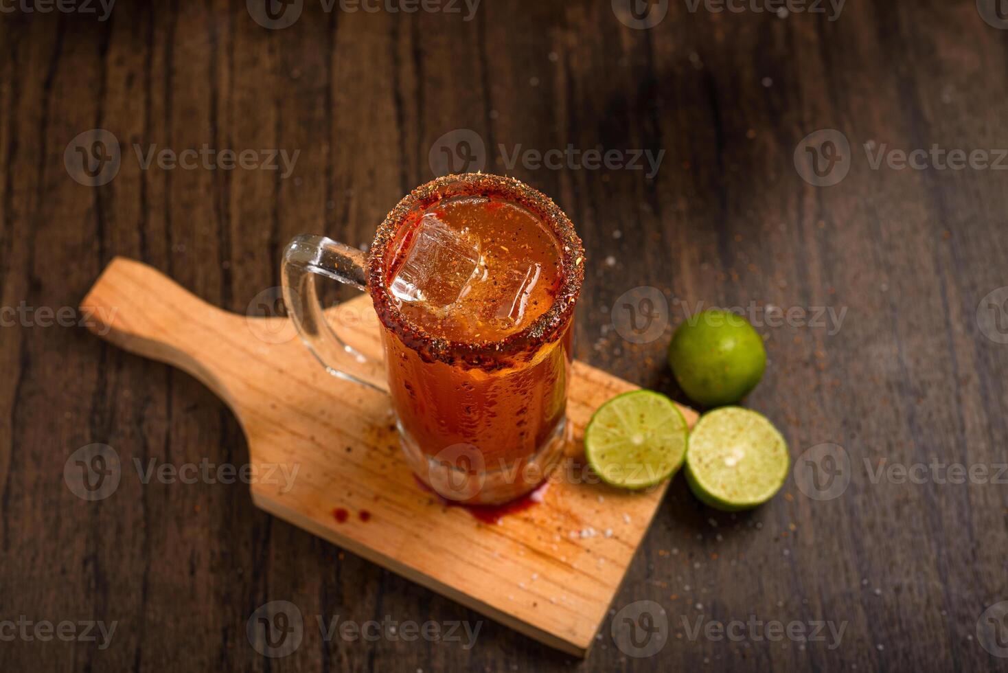 Michelada, typical mexican cocktail on a wooden table. Beer cocktail. photo