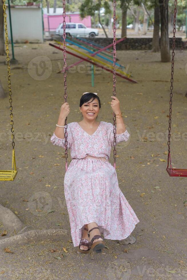 mujer balanceo en un al aire libre parque. foto