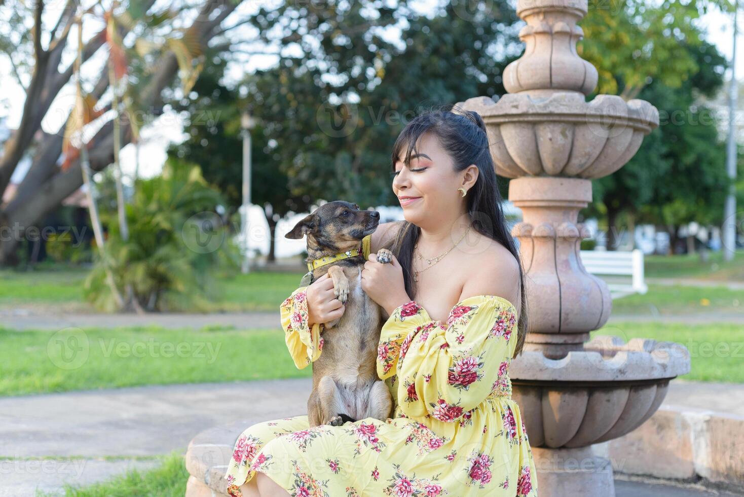 Woman hugging her pet in a public garden at sunset. Dog lover. photo