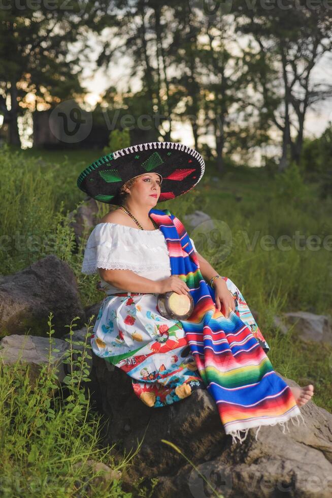 Woman with Mexican hat in rural scenery. Cinco de Mayo celebration in Mexico. photo