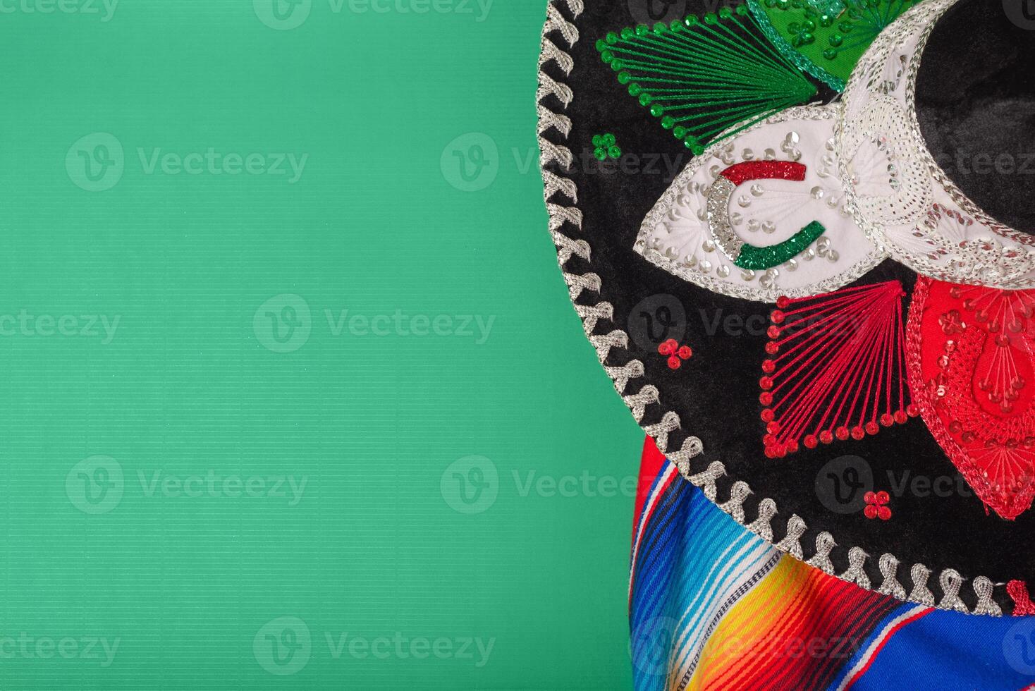 Mariachi hat and serape on green background. Mexican independence concept. Cinco de mayo background. photo