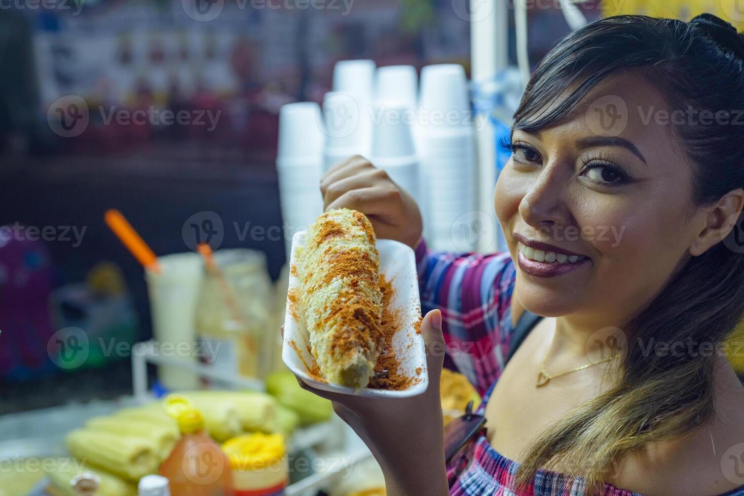 Mexican woman preparing a boiled corn, typical Mexican street food. Food stall. Elote. photo