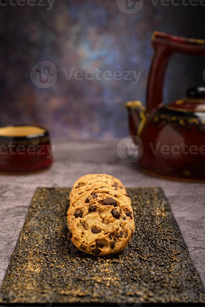 vainilla chocolate chip galletas con té conjunto en el antecedentes en cemento mesa. foto