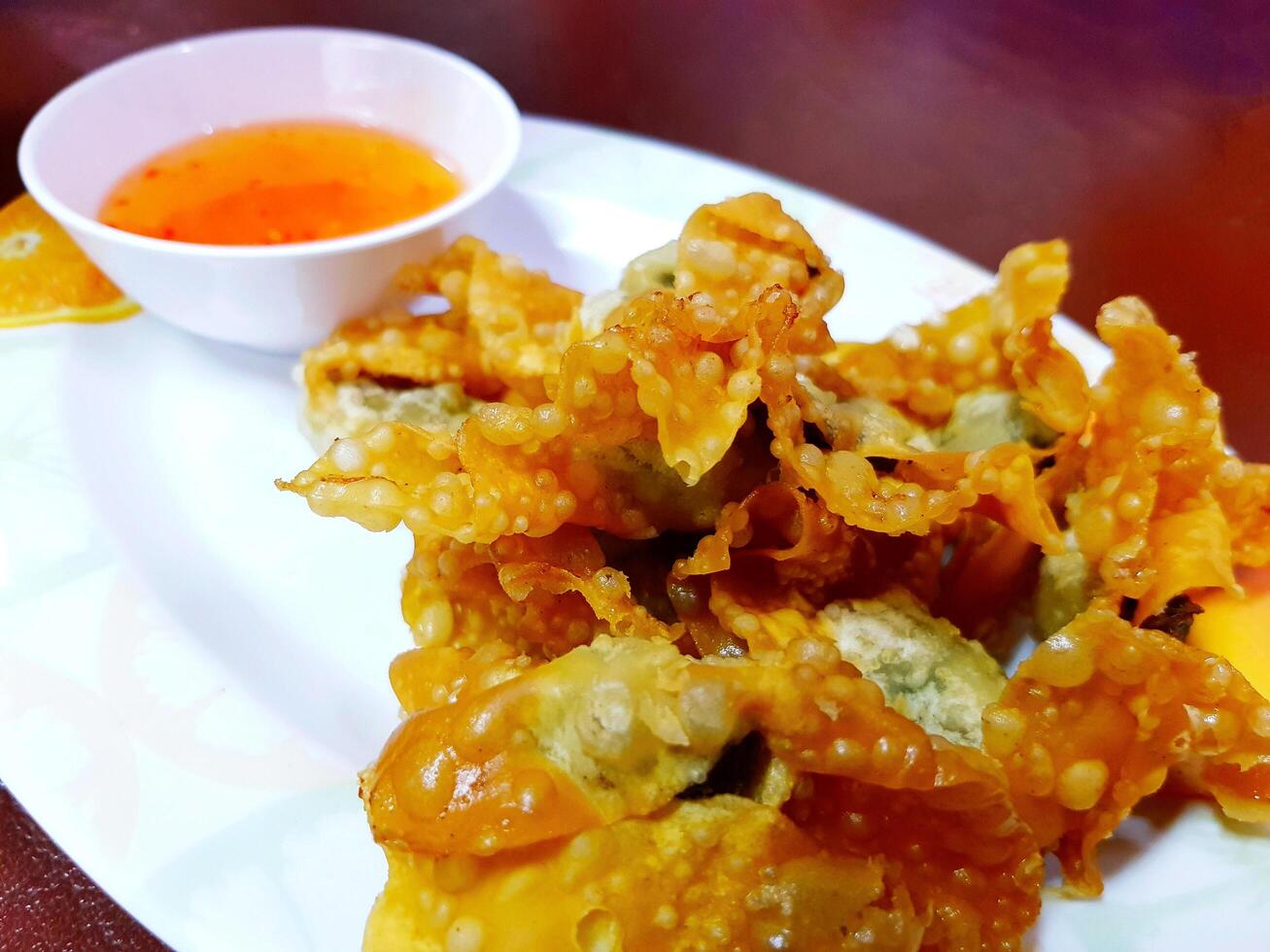 Close up fried dumplings with sweet sauce on white plate. Snack on dish, Asian food style and crispy. photo